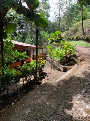 a house with a fence next to a dirt road at Cabañas Luz de Luna