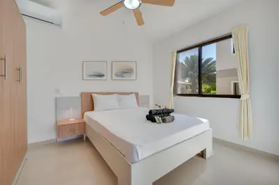 a white bedroom with a bed and a window at Casa Calm - Villaggio 6 in Potrero