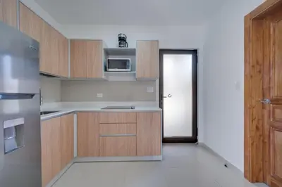an empty kitchen with wooden cabinets and a door at Casa Calm - Villaggio 6 in Potrero