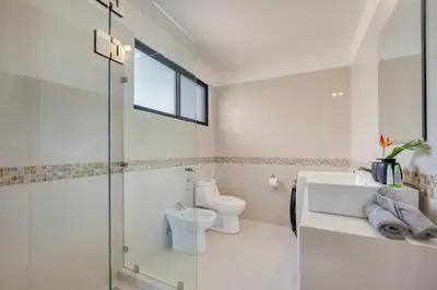 a white bathroom with a toilet and a sink at Casa Calm - Villaggio 6 in Potrero