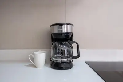 a black coffee maker and a cup on a counter at Casa Calm - Villaggio 6 in Potrero