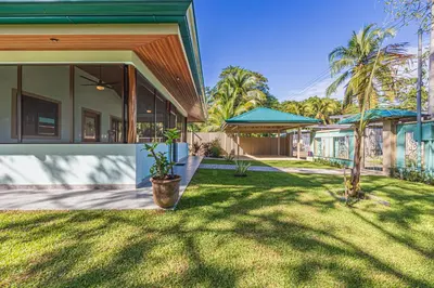a house with a green yard with a plant at Villa Tortuga- 3 Minute Walk to the Beach in Savegre