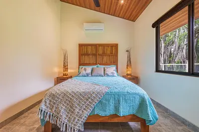 a bedroom with a bed and a window at Villa Tortuga- 3 Minute Walk to the Beach in Savegre