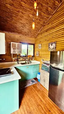 a large kitchen with wooden walls and wooden floors at Cabaña Colibrí - Parking in Sarchí