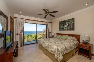 a bedroom with a bed and a view of the ocean at Playa Flamingo Ocean View Retreat in Playa Flamingo