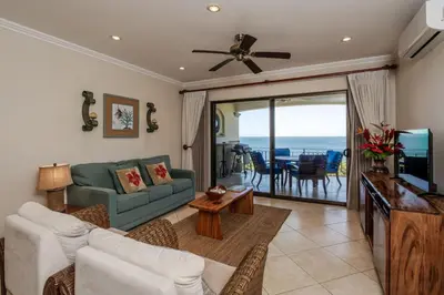 a living room with a couch and a television at Playa Flamingo Ocean View Retreat in Playa Flamingo