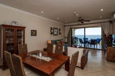 a living room with a wooden table and chairs at Playa Flamingo Ocean View Retreat in Playa Flamingo