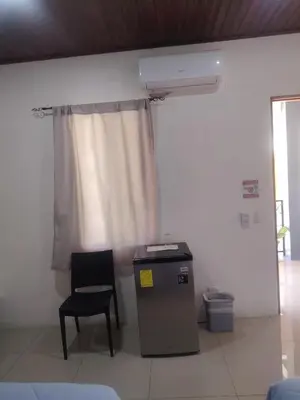 a room with a table and a chair and a window at Las Morenas in Nosara