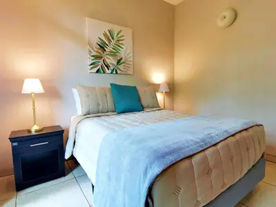 a bedroom with a large bed with a blue blanket at Majestic View House in Dominical, Oceanview in San Luis