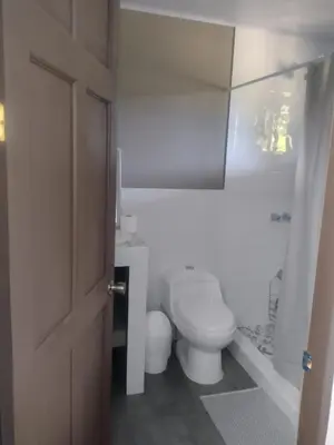 a white bathroom with a toilet and a shower at Marea Place in Carrillo