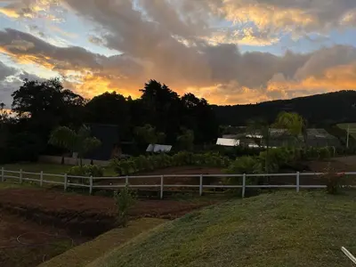 a fence in a field with a sunset in the background at Green haven in Alajuela City
