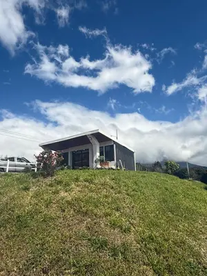 a small house on top of a grassy hill at Green haven in Alajuela City