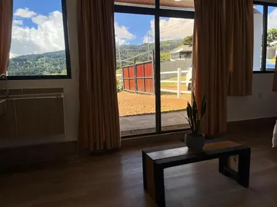 a room with a large window with a plant on a table at Green haven in Alajuela City