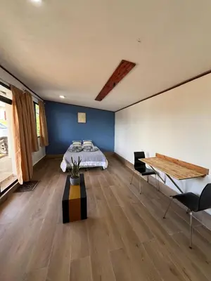 a bedroom with a bed and a table with chairs at Green haven in Alajuela City