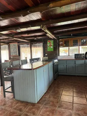 a kitchen with a bar in a building at Cabaña Brisa Del Río in Cooper