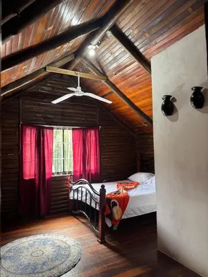 a bedroom with a bed in a wooden house at Cabaña Brisa Del Río in Cooper