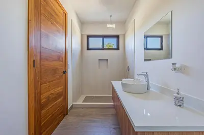 a bathroom with a sink and a wooden door at Casa Samay in Playa Avellana