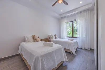 a white room with two beds and a window at Casa Samay in Playa Avellana
