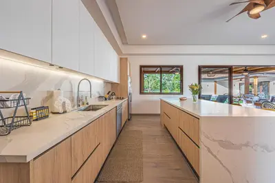 a large kitchen with wooden cabinets and white counter tops at Casa Samay in Playa Avellana