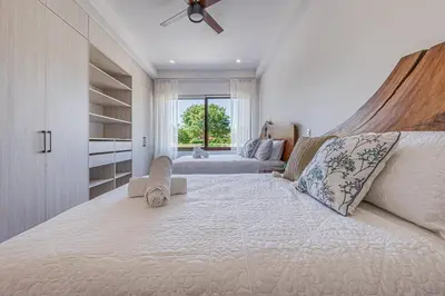 a large white bed in a room with a window at Casa Samay in Playa Avellana