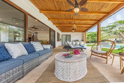 a living room with a blue couch and a table at Casa Samay in Playa Avellana
