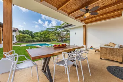 a dining room with a table and chairs and a pool at Casa Samay in Playa Avellana