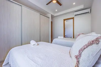 a bedroom with two beds with white sheets at Casa Samay in Playa Avellana