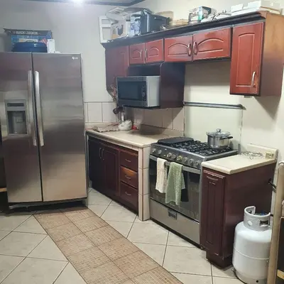 a kitchen with a stove and a refrigerator at Rooms For RENT, Roommates, Or As BB in Heredia