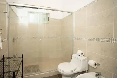 a bathroom with a toilet and a glass shower at Appartamento Oasis Azul in Potrero