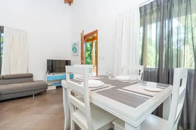 a dining room with a white table and chairs at Appartamento Oasis Azul in Potrero