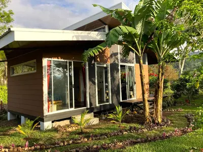 a small house with a palm tree in front of it at Casas Kawö y Tulu
