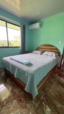 a bedroom with a large bed with blue walls at La Casa Tropical in Guayabal