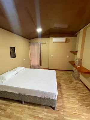 a bedroom with a white bed in a room at Cabinas en Cañas Guanacaste in Cañas