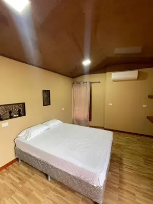 a bedroom with a white bed in a room at Cabinas en Cañas Guanacaste in Cañas