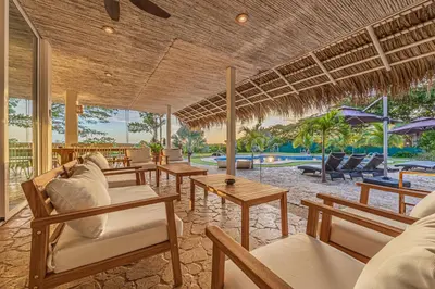 a resort with tables and chairs and a pool at Casa Colinas Pickleball in Playa Grande