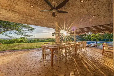 a dining room with a long table and chairs at Casa Colinas Pickleball in Playa Grande