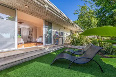 a yard with a bench and a house at Casa Colinas Pickleball in Playa Grande