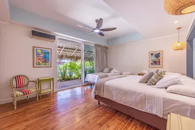a bedroom with two beds and a ceiling fan at Casa Colinas Pickleball in Playa Grande