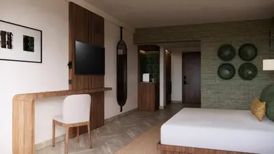 a bedroom with a bed and a desk with a television at Montara Hotel, Tapestry Collection By Hilton in Heredia