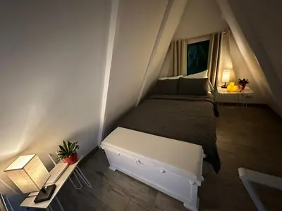 a small bedroom with a bed and a table at Casa Jardin BV