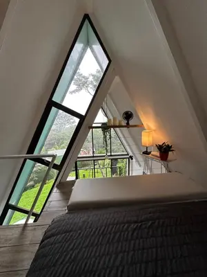 a bedroom with a large window in a attic at Casa Jardin BV
