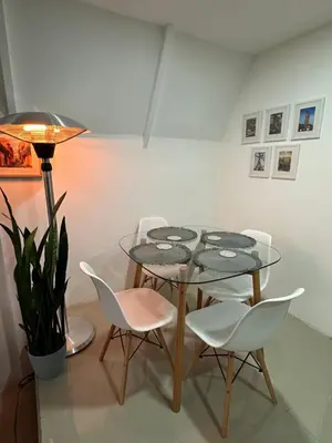 a dining room with a glass table and white chairs at Casa Jardin BV