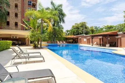 a swimming pool with lounge chairs next to a building at Pen11 Coastal Retreat w Pool and Ocean View Rooftop in Tamarindo