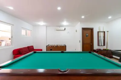 a pool table in a living room with a couch at Pen11 Coastal Retreat w Pool and Ocean View Rooftop in Tamarindo