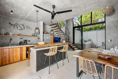 a kitchen with a table and chairs and a staircase at TL1 Bright Stylish Loft with Green Views in Tamarindo