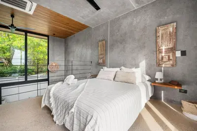 a bedroom with a large white bed and a window at TL1 Bright Stylish Loft with Green Views in Tamarindo