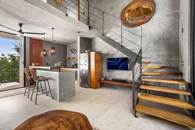 a kitchen with a staircase and a table in a room at TL1 Bright Stylish Loft with Green Views in Tamarindo