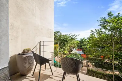 a balcony with chairs and a view of a garden at TL1 Bright Stylish Loft with Green Views in Tamarindo