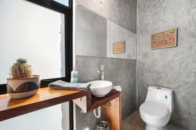 a bathroom with a white toilet and a sink at TL1 Bright Stylish Loft with Green Views in Tamarindo