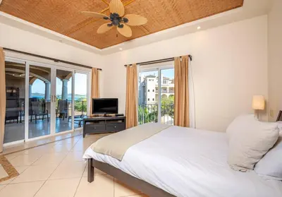 a bedroom with a bed and a ceiling fan at Elegant Oceanview 2BR Condo 2-Min Walk to Beach in Tamarindo